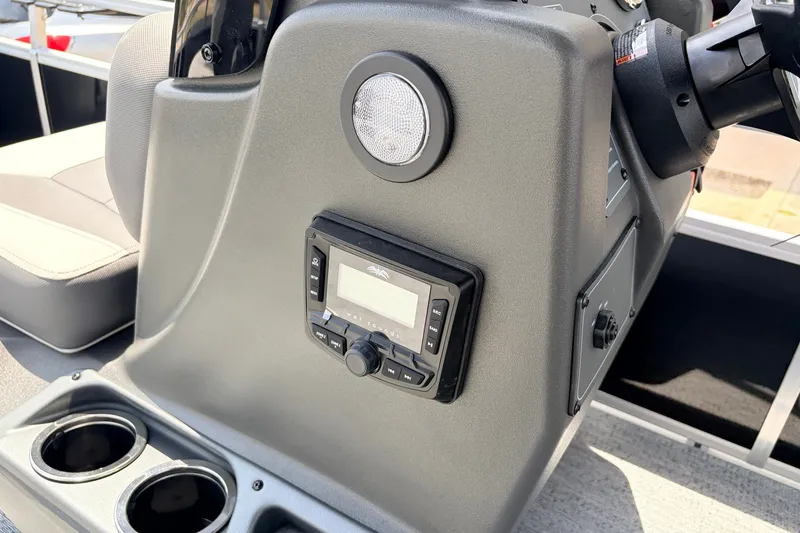 Slide: The Image of Control panel of 2027 Sun Tracker Bass Buggy 18 DLX with audio system and cup holders. - 25