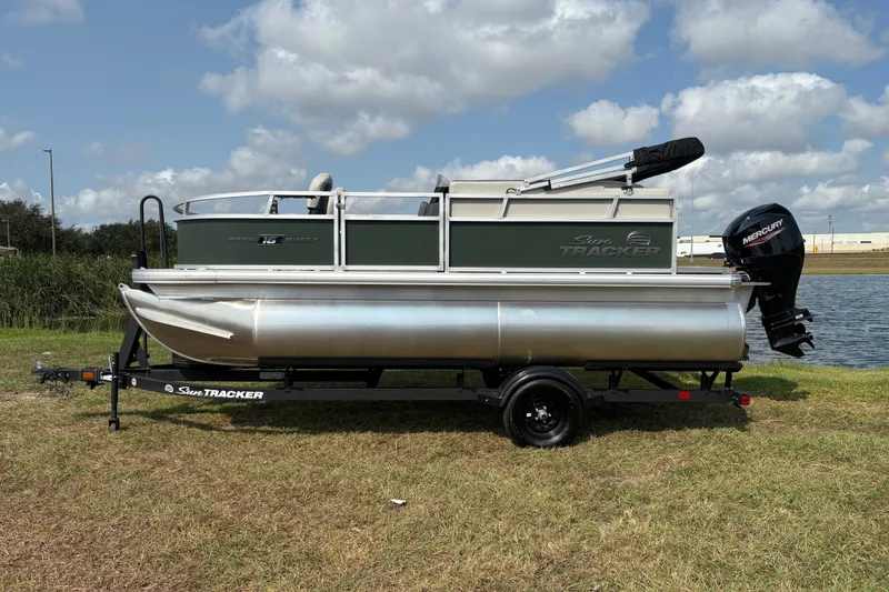 Slide: The Image of 2027 Sun Tracker Bass Buggy 16 XL Select pontoon boat on trailer by a lake. - 60