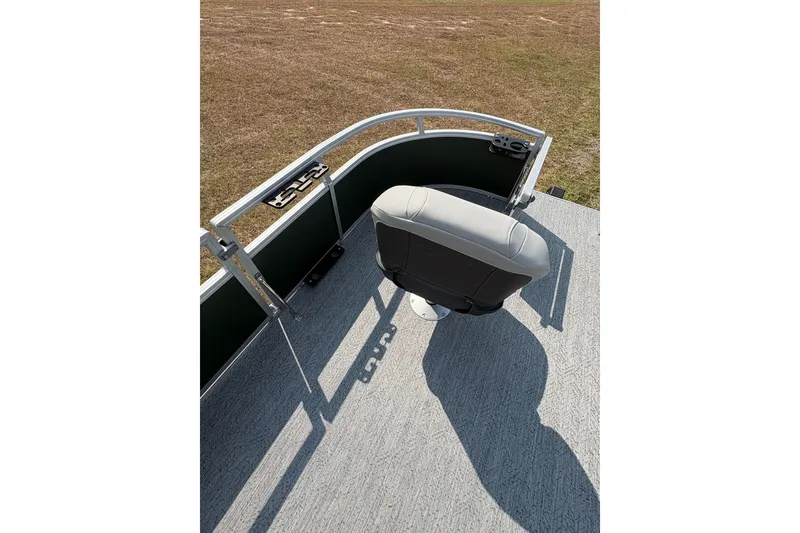 Slide: The Image of 2027 Sun Tracker Bass Buggy 16 XL Select boat seat on deck, grassy background. - 67