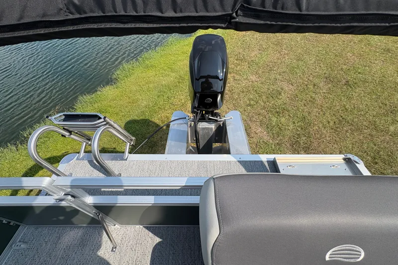 Slide: The Image of 2027 Sun Tracker Bass Buggy 16 XL Select pontoon boat with motor and ladder by the water. - 74