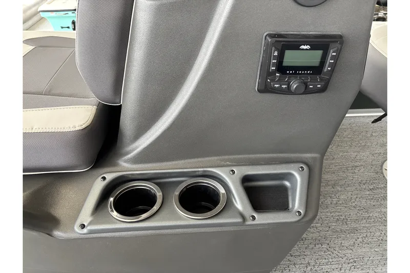 Slide: The Image of 2027 Sun Tracker Bass Buggy 16 XL Select interior with cup holders and audio controls. - 16