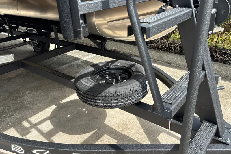 Slide: The Image of 2027 Sun Tracker Bass Buggy 16 XL Select trailer with spare tire attached. - 26