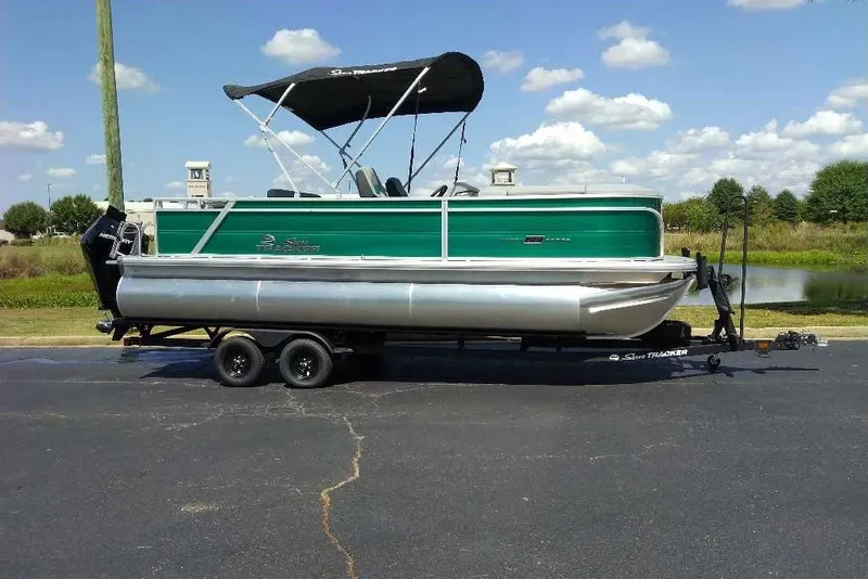 The Image of 2027 Sun Tracker Party Barge 22 RF XP3 pontoon boat on trailer, parked outdoors. - 0