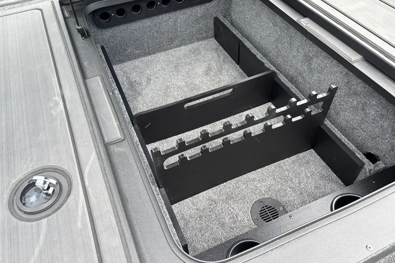 Slide: The Image of Storage compartment of 2027 Tracker Savage 215 boat with rod holders and carpeted interior. - 26