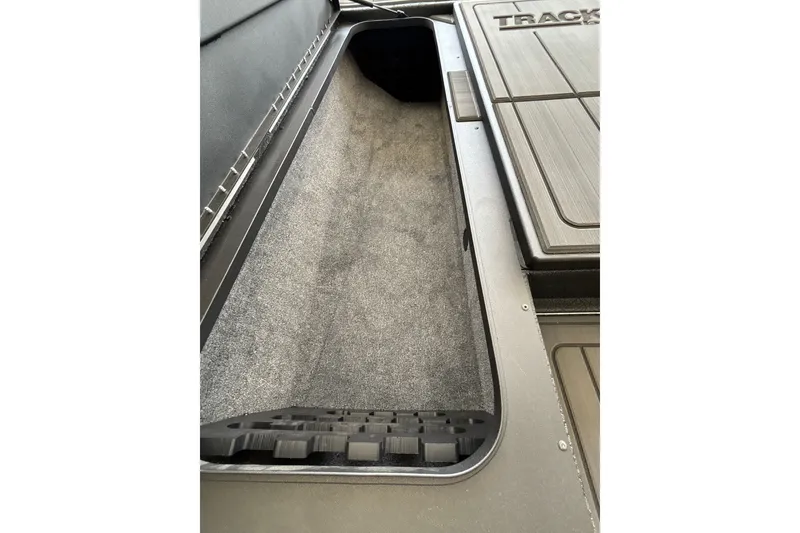 Slide: The Image of Interior storage compartment of 2027 Tracker Savage 215 boat, featuring carpeted flooring. - 28
