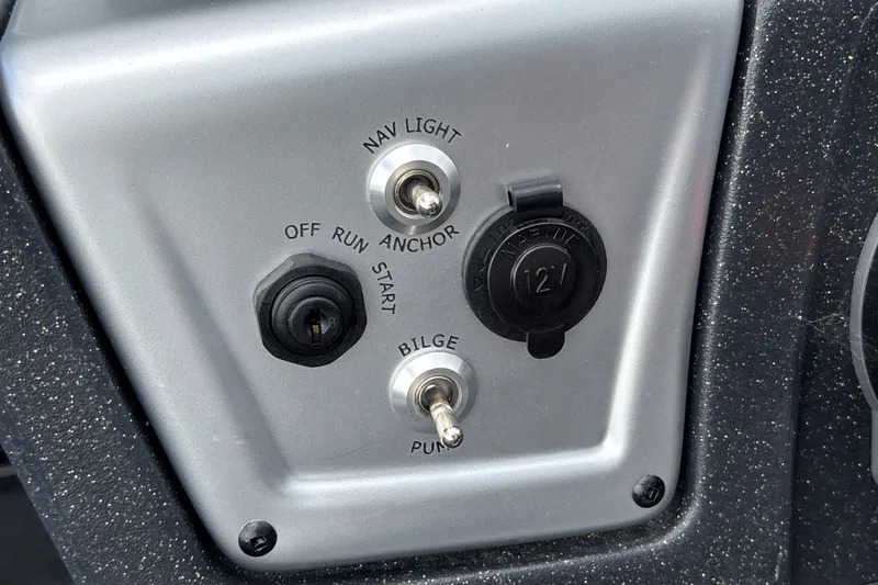 Slide: The Image of Control panel of 2027 Tracker Savage 215 boat with switches and 12V outlet. - 21