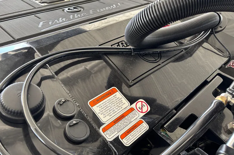 Slide: The Image of Close-up of 2027 Tracker Savage 215 boat engine with warning labels and cables. - 34