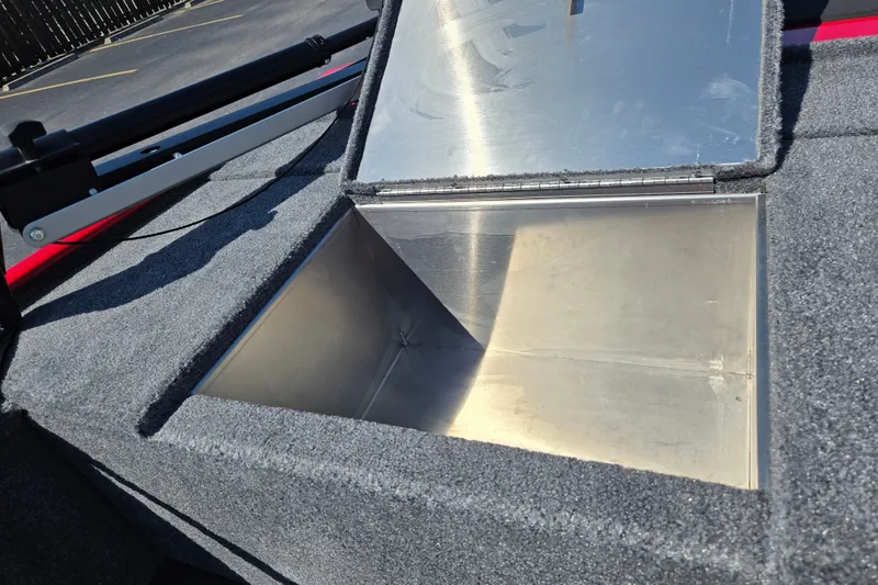 Slide: The Image of Open storage compartment on 2027 Tracker Panfish 17 boat, featuring carpeted interior. - 15