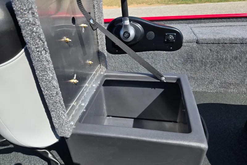 Slide: The Image of 2027 Tracker Panfish 17 boat storage compartment with open lid and control panel. - 17