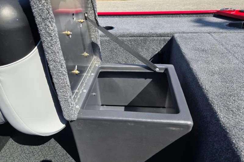 Slide: The Image of Open storage compartment in 2027 Tracker Panfish 17 boat, featuring carpeted interior and secure latch. - 18