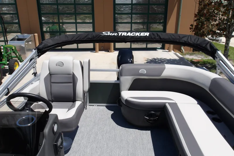 Slide: The Image of 2027 Sun Tracker Bass Buggy 16 XL Select pontoon boat interior with seating and steering console. - 16