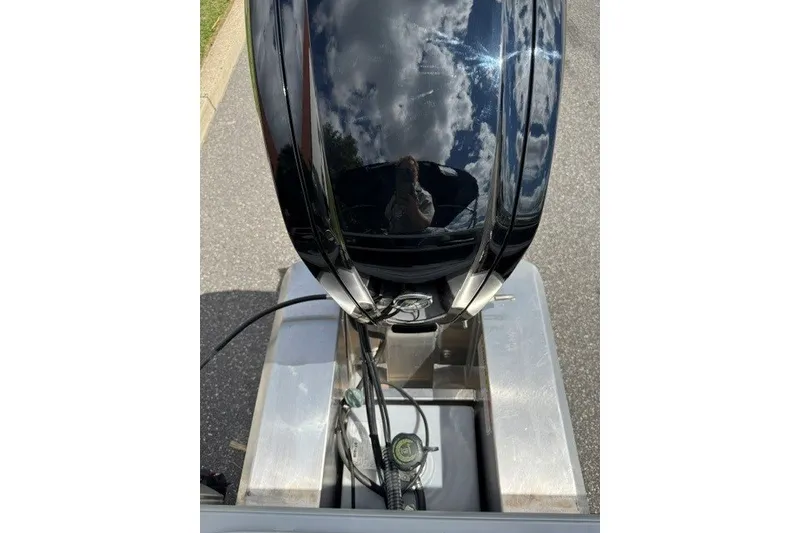 Slide: The Image of 2027 Sun Tracker Bass Buggy 18 DLX outboard motor with reflective surface and cables. - 18