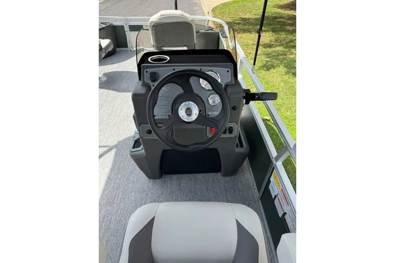 Slide: The Image of 2027 Sun Tracker Bass Buggy 18 DLX steering console with modern controls and seating. - 16