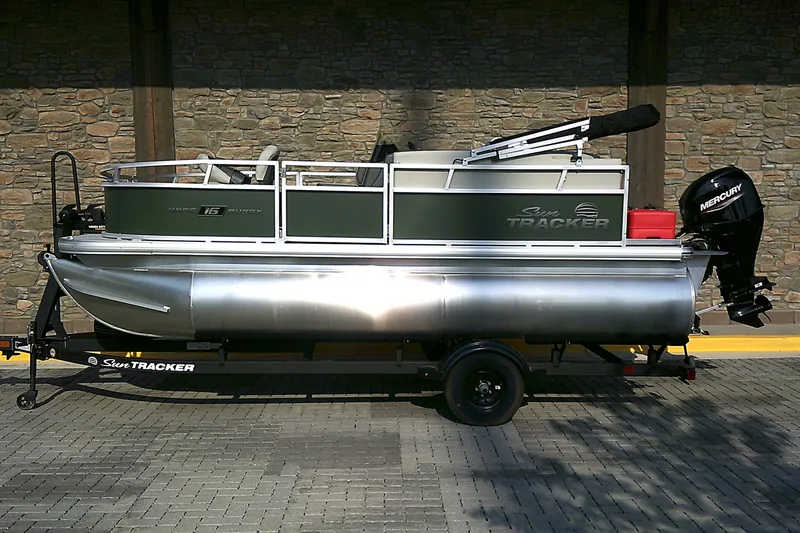 The Image of 2027 Sun Tracker Bass Buggy 16 XL Select pontoon boat on trailer, side view. - 0