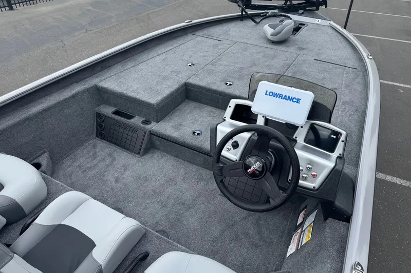 Slide: The Image of 2027 Tracker Savage 215 boat interior with steering wheel and Lowrance navigation system. - 13