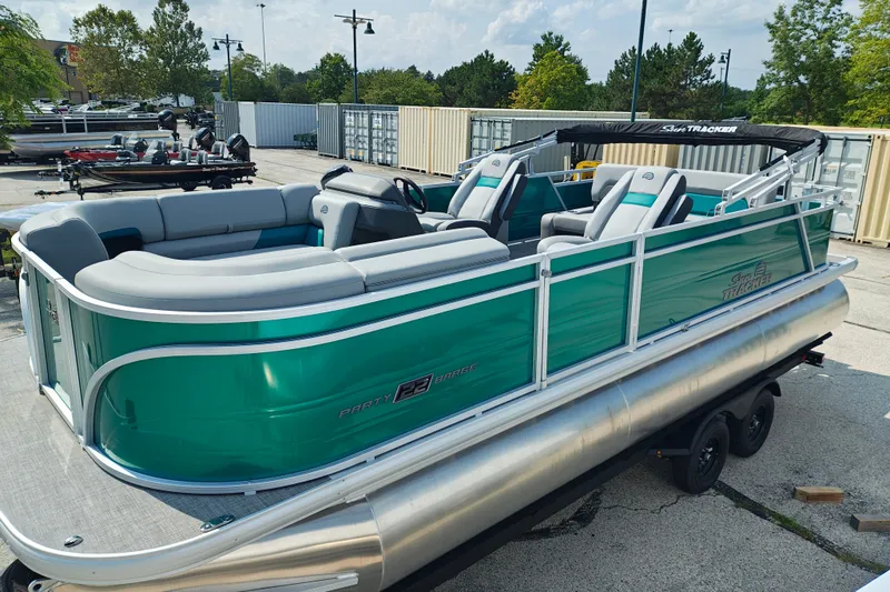 The Image of 2027 Sun Tracker Party Barge 22 RF XP3 pontoon boat with teal exterior and spacious seating. - 1