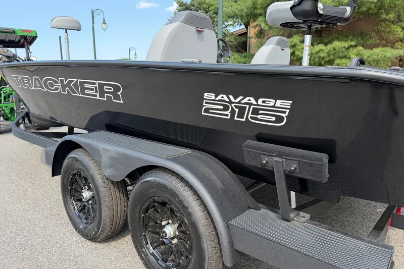 Slide: The Image of 2027 Tracker Savage 215 boat on trailer, black exterior, parked outdoors. - 52
