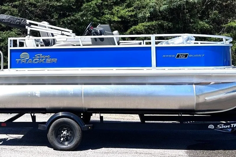 The Image of 2027 Sun Tracker Bass Buggy 16 XL Select pontoon boat on trailer, side view. - 0