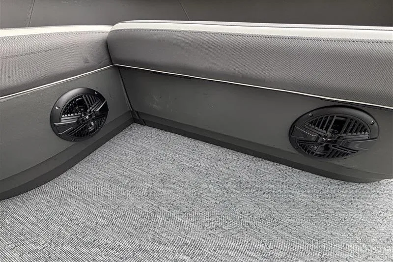 Slide: The Image of Interior of 2027 Sun Tracker Bass Buggy 18 DLX with speakers and cushioned seating. - 23