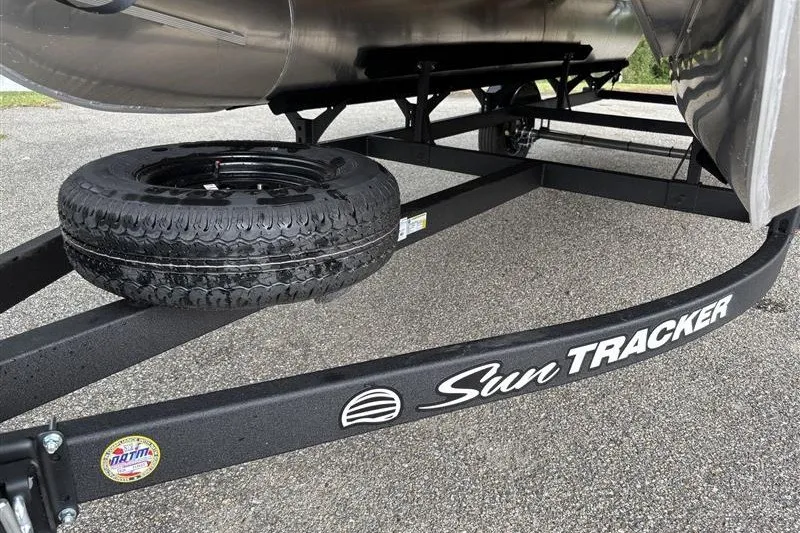 Slide: The Image of Trailer of 2027 Sun Tracker Bass Buggy 18 DLX with spare tire on asphalt. - 31