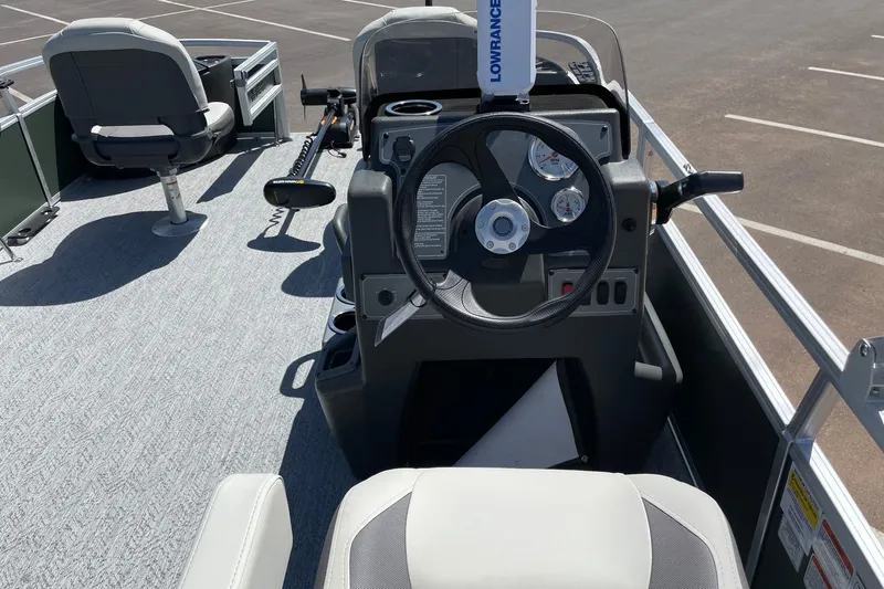 Slide: The Image of 2027 Sun Tracker Fishin' Barge 22 XP3 boat interior with steering wheel and seating. - 14