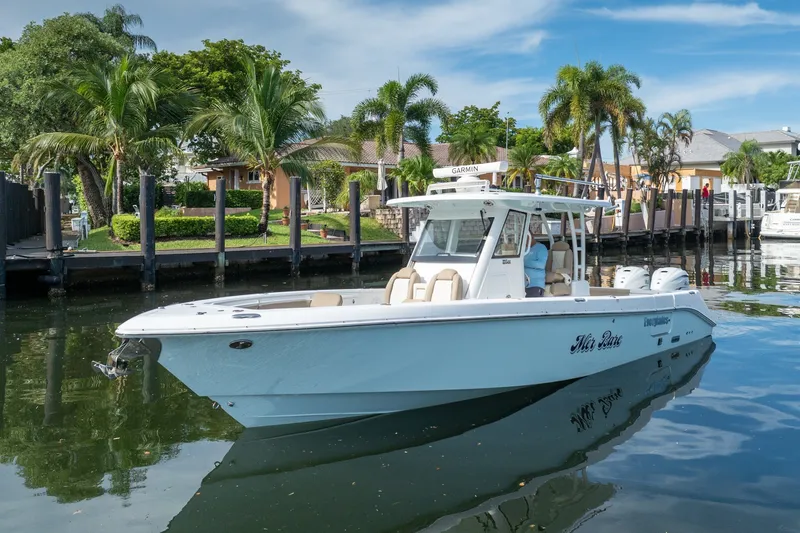 Slide: The Image of 2020 Everglades 355 Center Console boat docked near tropical waterfront homes. - 2
