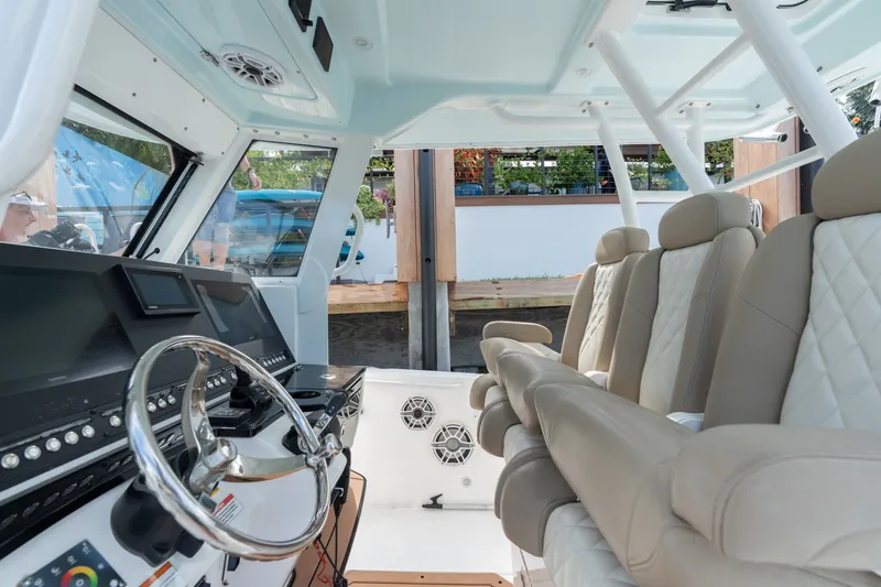 Slide: The Image of Interior of 2020 Everglades 355 Center Console boat with beige seating and modern dashboard. - 10