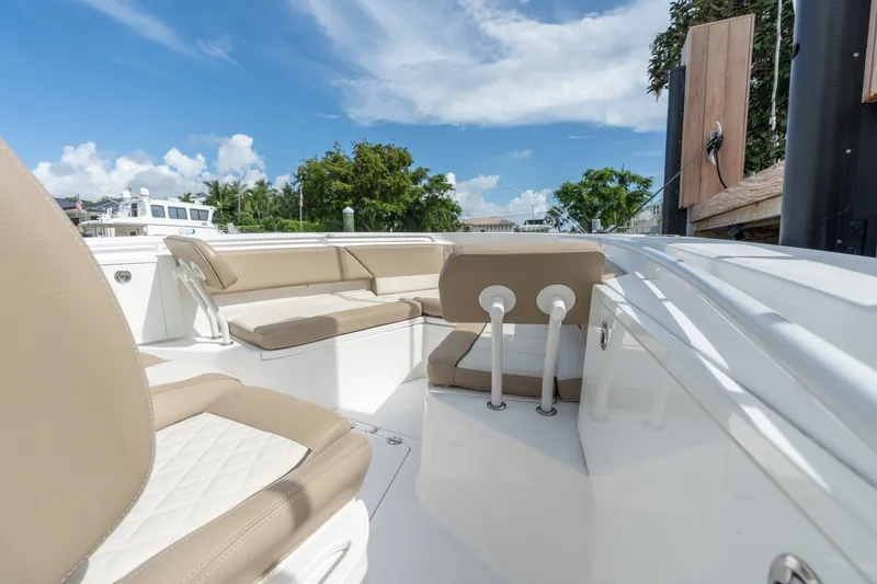 Slide: The Image of 2020 Everglades 355 Center Console boat interior with beige seating under a clear blue sky. - 17
