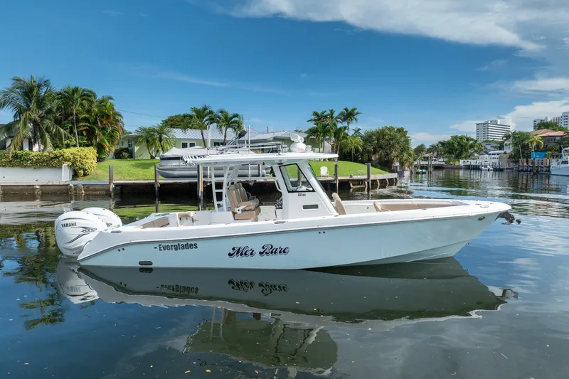 Slide: The Image of 2020 Everglades 355 Center Console boat on calm water, surrounded by lush greenery. - 4