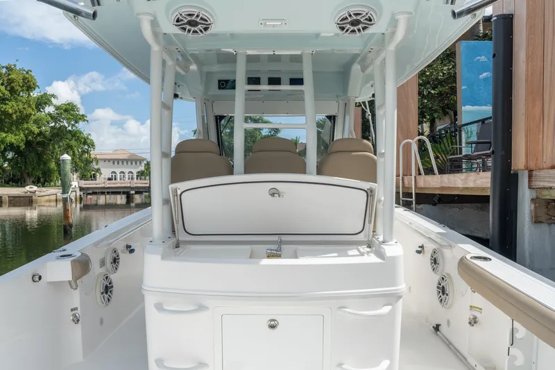Slide: The Image of 2020 Everglades 355 Center Console boat interior with seating and storage, docked by waterfront. - 24