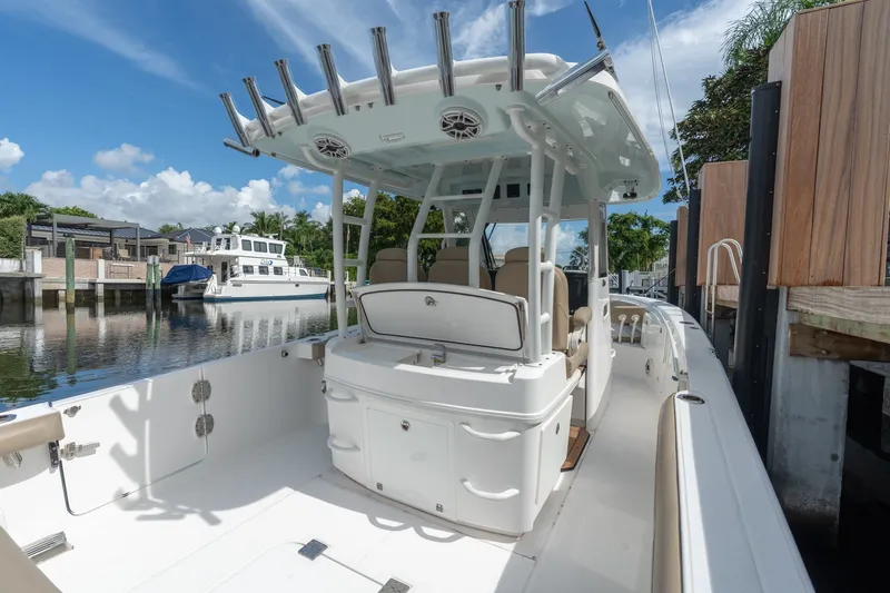 Slide: The Image of 2020 Everglades 355 Center Console boat docked by waterfront homes under a clear blue sky. - 25