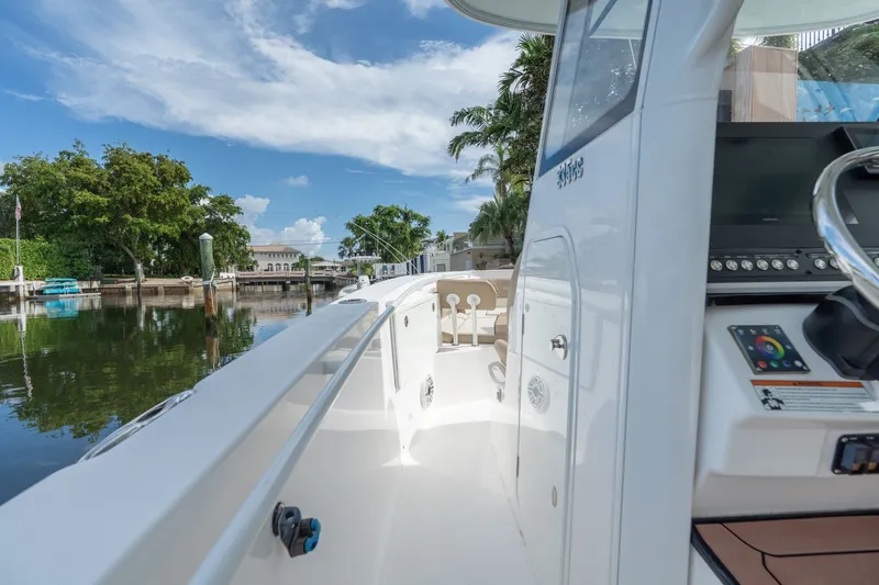 Slide: The Image of 2020 Everglades 355 Center Console boat docked by a scenic waterfront. - 15