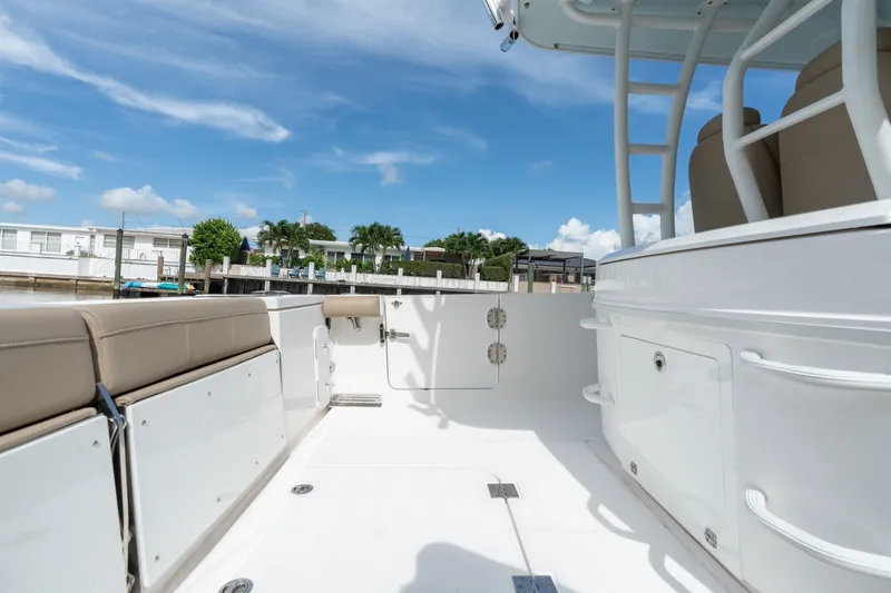 Slide: The Image of 2020 Everglades 355 Center Console boat interior with seating and storage, under clear blue sky. - 13