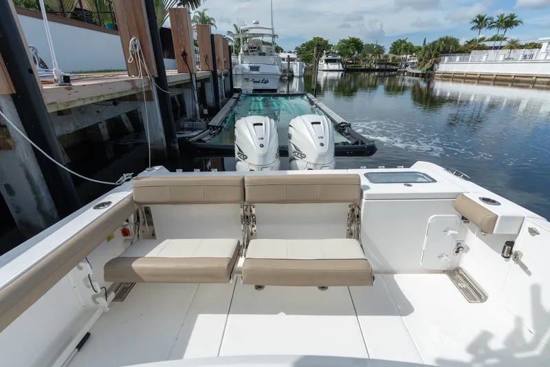 Slide: The Image of 2020 Everglades 355 Center Console boat docked, featuring twin outboard engines and seating area. - 23