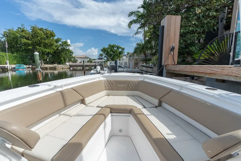 Slide: The Image of 2020 Everglades 355 Center Console boat with spacious seating, docked by lush greenery. - 19
