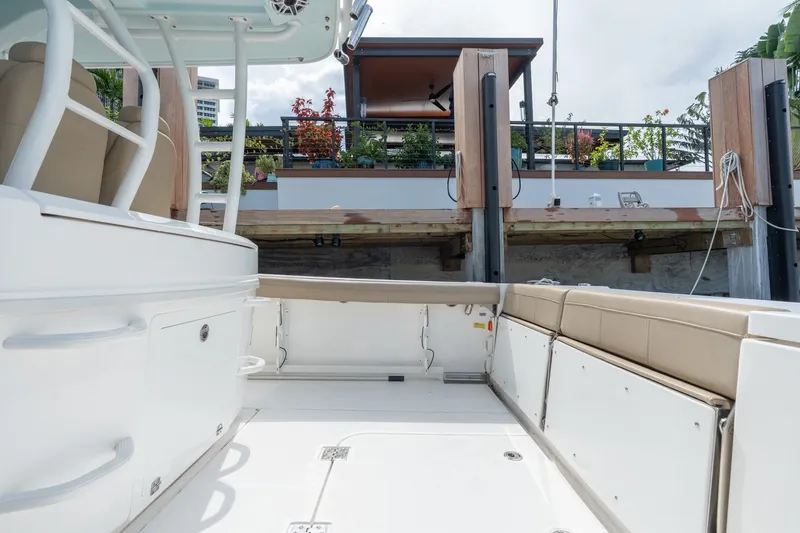 Slide: The Image of 2020 Everglades 355 Center Console boat interior with beige seating and dock view. - 14