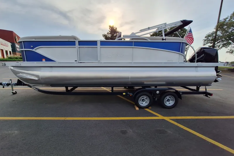 Slide: The Image of 2023 Barletta Cabrio 22QC pontoon boat on trailer in parking lot. - 1