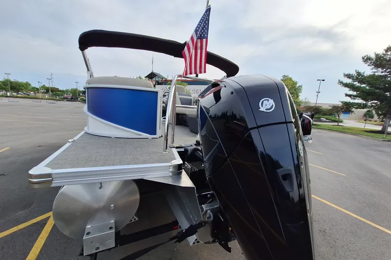 Slide: The Image of 2023 Barletta Cabrio 22QC pontoon boat with American flag and powerful outboard motor. - 8