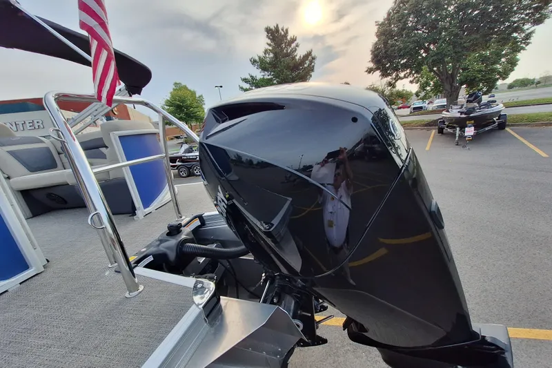 Slide: The Image of 2023 Barletta Cabrio 22QC pontoon boat with sleek black motor, parked outdoors. - 10