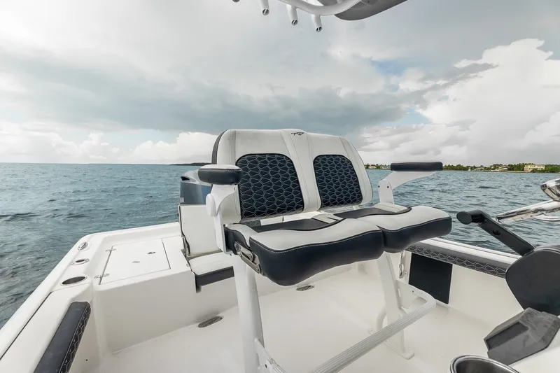 Slide: The Image of 2024 Tidewater 2300 Carolina Bay boat interior with dual seating, ocean backdrop. - 17