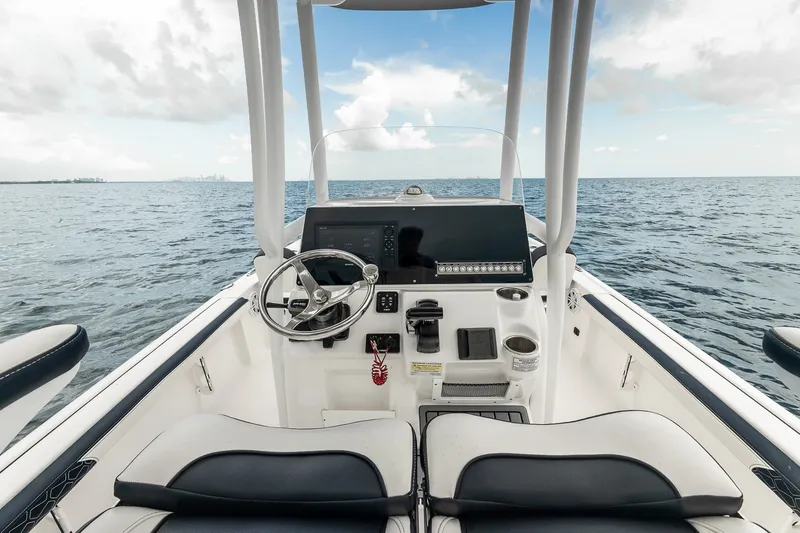 Slide: The Image of 2024 Tidewater 2300 Carolina Bay boat interior with steering wheel, dashboard, and ocean view. - 20