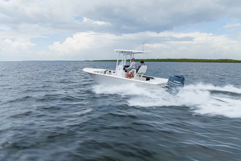 Slide: The Image of 2024 Tidewater 2300 Carolina Bay boat cruising on open water under a cloudy sky. - 16