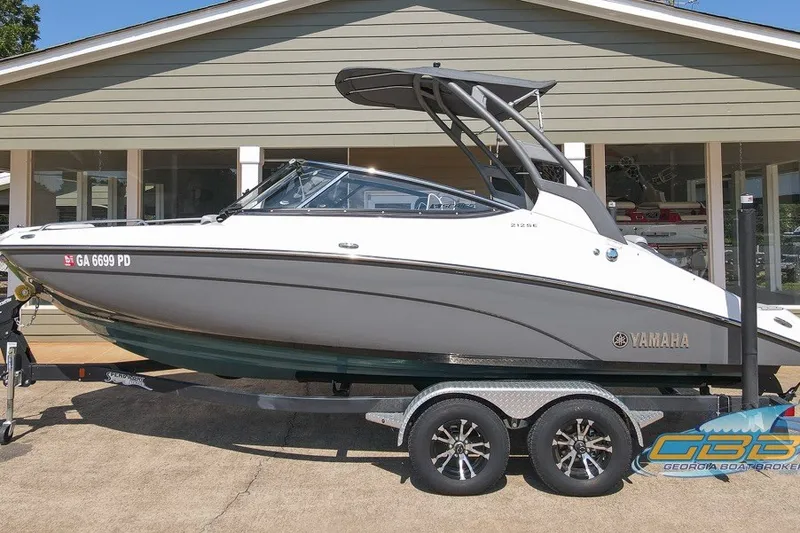 The Image of 2022 Yamaha Boats 212SE on trailer outside a showroom. - 0