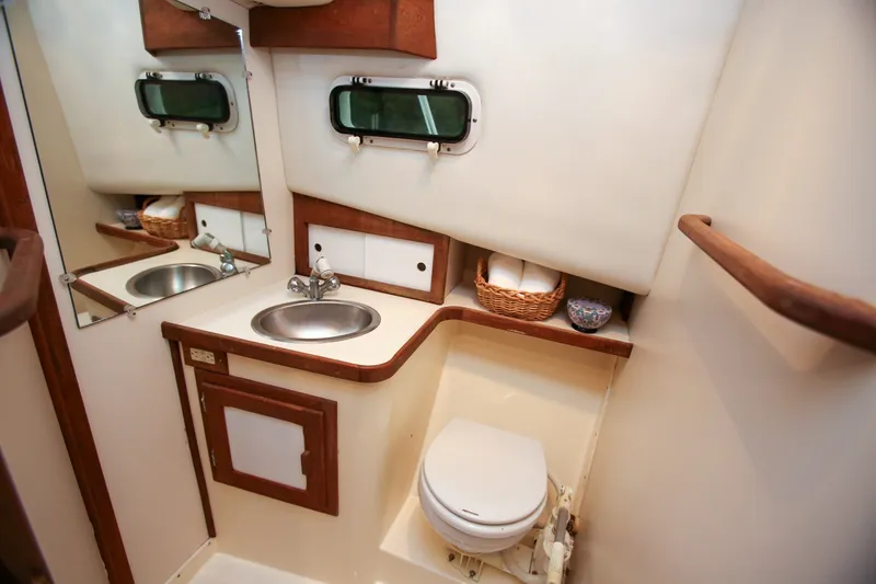 Slide: The Image of Compact bathroom in 1995 Nauset 28 Bridgedeck boat with sink, toilet, and storage. - 19