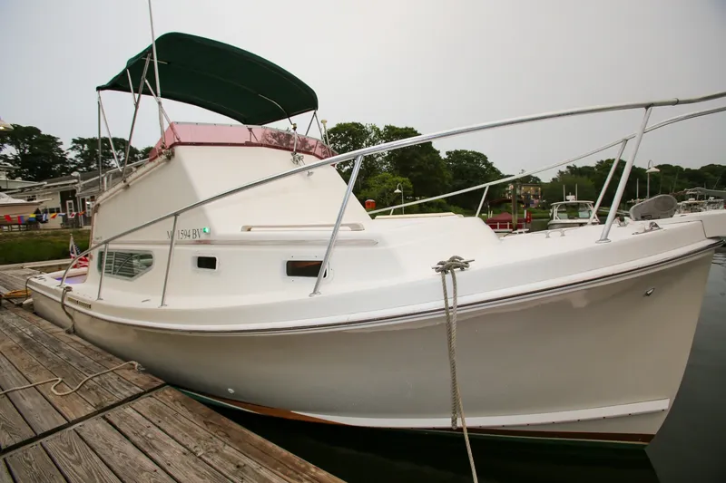 Slide: The Image of 1995 Nauset 28 Bridgedeck boat docked at a marina with green canopy. - 24