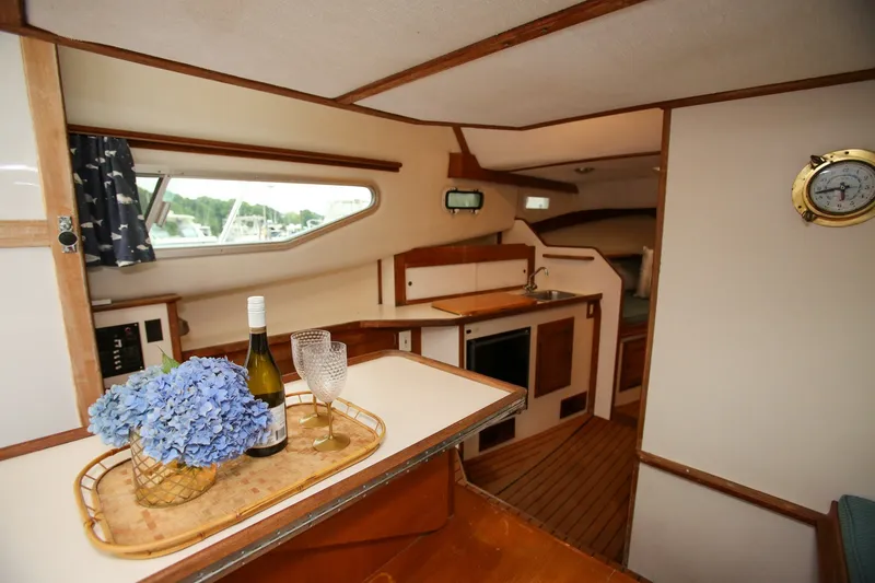 Slide: The Image of Interior of 1995 Nauset 28 Bridgedeck boat with kitchen and dining area. - 23