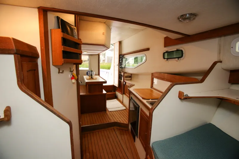 Slide: The Image of Interior of 1995 Nauset 28 Bridgedeck boat with wooden cabinetry and compact kitchen area. - 21