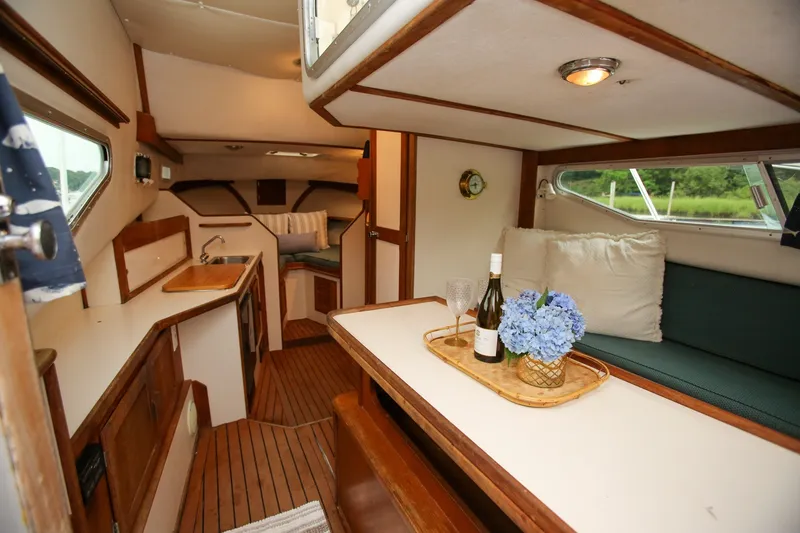 Slide: The Image of Interior of 1995 Nauset 28 Bridgedeck boat with cozy seating and wooden accents. - 17