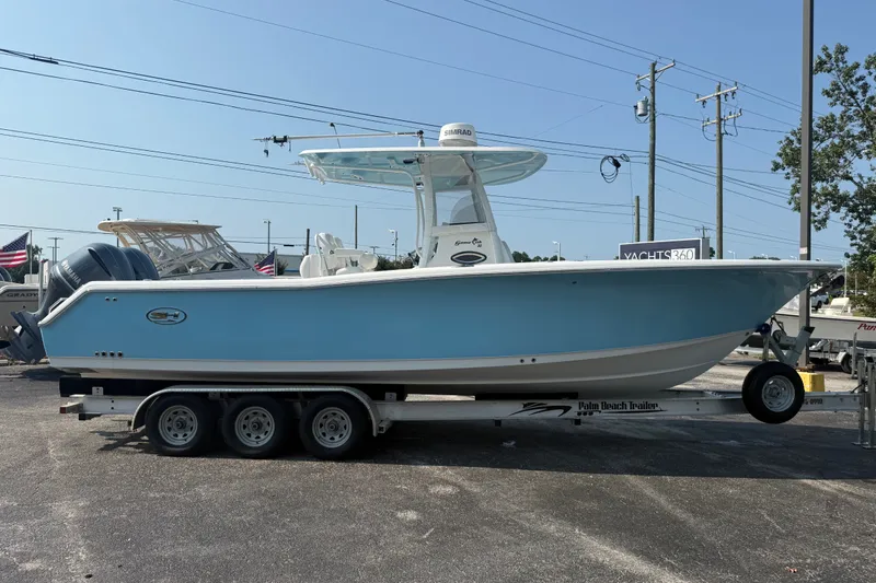 Slide: The Image of 2015 Sea Hunt Gamefish 30CB boat on trailer, light blue hull, parked outdoors. - 2
