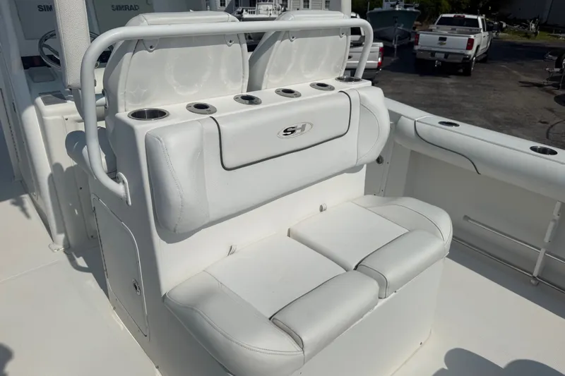 Slide: The Image of 2015 Sea Hunt Gamefish 30CB boat interior with white seating and cup holders. - 11